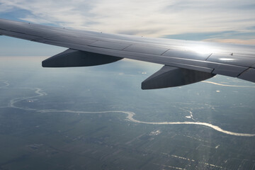Obraz premium Wing airplane flying above Netherlands with view at river Lek
