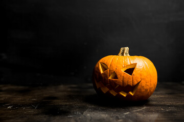 Moody scary Halloween pumpkin jack o'lantern on dark background