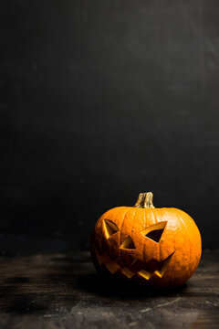 Moody scary Halloween pumpkin jack o'lantern on dark background