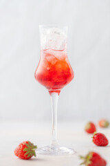 Strawberry liqueur with ice in a glass.