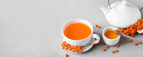 Composition with cup of tasty rowan tea, honey and berries on light background with space for text