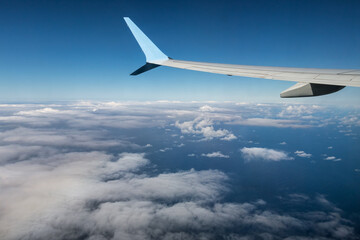Fototapeta na wymiar Wing airplane above Atlantic Ocean with view at white clouds