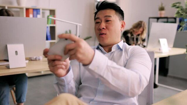 Lazy bored office worker playing mobile games in office during boring work day. Relaxation and job concept. High quality 4k footage