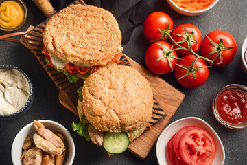Fresh doner kebab in buns and ingredients on dark background