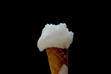 Lemon ice cream in a waffle cone - lemon sorbet on a black background