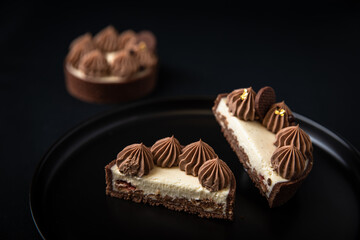 Tarte Schoko-Cheesecake. Feiner Cheesecake mit natürlicher Vanilleschote und einer haube aus Schokolade. Schrarze Hintergrund. 