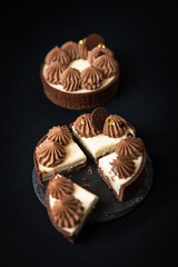Tarte Schoko-Cheesecake. Feiner Cheesecake mit natürlicher Vanilleschote und einer haube aus Schokolade. Schrarze Hintergrund. 