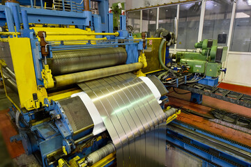 Packed rolls of steel sheet, cold rolled steel coils in factory building.