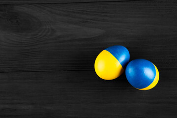 easter egg with the flag of Ukraine on a wooden background.