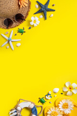 Summer beach design concept with shells, hat, slipper on yellow background.