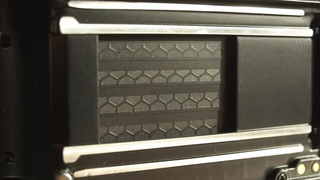 Macro-shot of resetting shutter blades made of titanium with a honeycomb pattern of a vintage analog camera.
