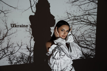 Patriotic shooting in support of Ukraine. Portrait of a Ukrainian girl under the digital light of a...