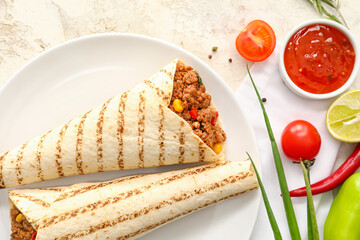 Plate with tasty burritos, sauce and vegetables on light background
