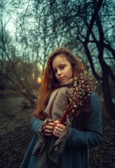 Portrait of a girl with a willow in a spring park