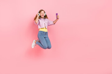 Fototapeta na wymiar Photo of dream lady jump hold telephone search playlist wear headphones jacket jeans isolated pink color background
