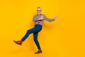 Fototapeta na wymiar Full size photo of cheerful mature man feeling young have fun dancing in club isolated on yellow color background