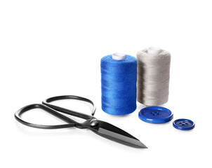 Thread spools, buttons and scissors on white background