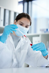 The clinical trial has gone well. Closeup shot of a young woman using a dropper and test tube while working with samples in a lab.