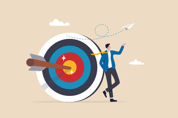 Business objective, purpose or target, goal and resolution to aim for success, aspiration and motivation to achieve goal concept, confident businessman stand with arrow hit bullseye on archery target. - obrazy, fototapety, plakaty