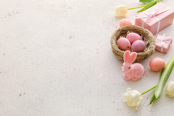 Composition with painted Easter eggs, gift boxes and tulip flowers on light background