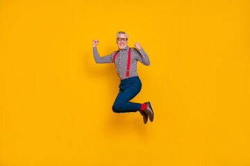 Fototapeta na wymiar Full body photo of laughing cheerful granddad jumping up in excitement celebrate victory isolated on yellow color background