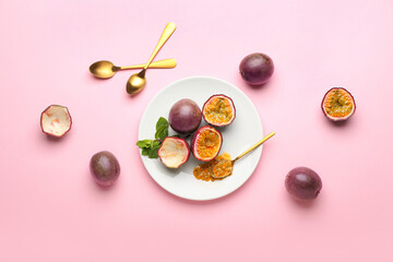Plate with delicious passion fruits on pink background