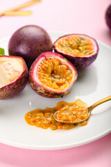 Plate with delicious passion fruits on pink background