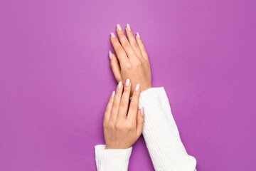 Female hands with beautiful manicure on purple background