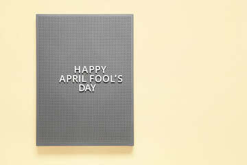 Grey board with text HAPPY APRIL FOOL'S DAY on yellow background