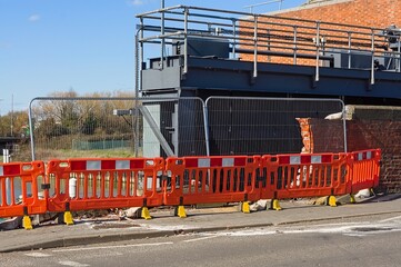Road barriers in front of damaged wall of a bridge after car accident