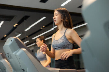 Fototapeta na wymiar Young asian woman exercising on treadmill at a gym.Active people running on treadmill. smile and funny emotion.