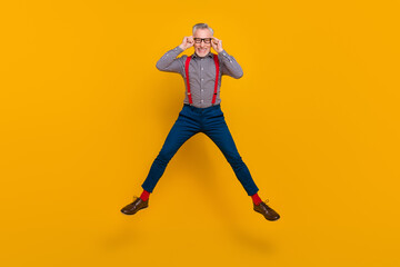 Fototapeta na wymiar Full body photo of energetic laughing confident businessman in spectacles isolated on yellow color background