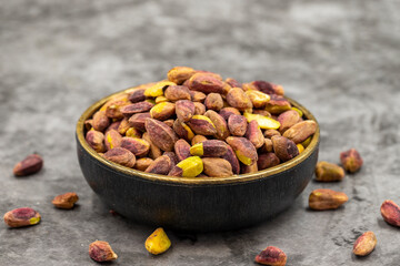 Pistachio kernel on dark background. A bowl of pistachios. close up