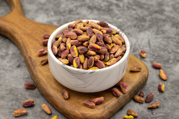 Pistachio kernel on dark background. A bowl of pistachios. close up