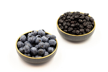 Raw and dried blueberries isolated on white background.Blueberries in bowl. Close-up.