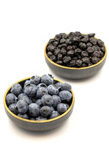 Raw and dried blueberries isolated on white background.Blueberries in bowl. Close-up.
