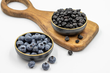 Raw and dried blueberries isolated on white background.Blueberries in bowl. Close-up.