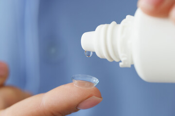 Drop of medical solution on soft contact lens closeup
