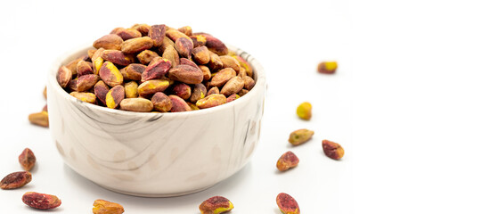 Pistachio kernel isolated on white background. A bowl of pistachios. close up. Copy space. Space for text