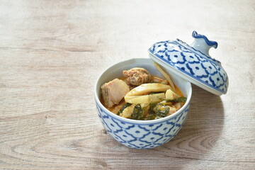 spicy boiled slice fresh bamboo shoot with chicken in coconut milk red curry soup on bowl