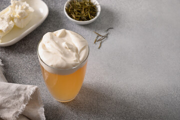 Chinese cheese tea made of white green tea with whipped cream cheese foam topped grey background....