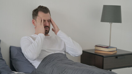 Fototapeta premium Man having Headache while Sleeping in Bed