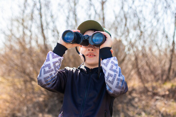 Child boy with binoculars in his hands