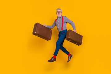 Full length photo of laughing positive pensioner running for his retirement isolated on yellow color background