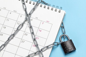 The calendar is wrapped in a chain and closed with a padlock. Blue background