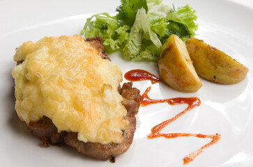 Baked meat with cheese, green salad and baked apples.