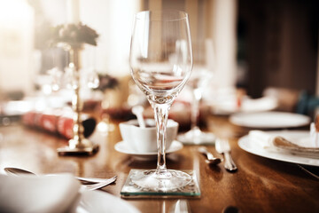 The scene is set for some Christmas festivities. Closeup shot of a wineglass on a table at Christmas.