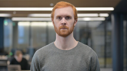 Portrait of Serious Young Man Looking at the Camera 