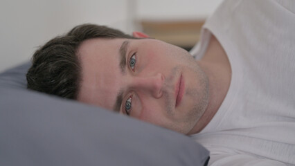 Man Awake in Bed Looking at Camera, Close up