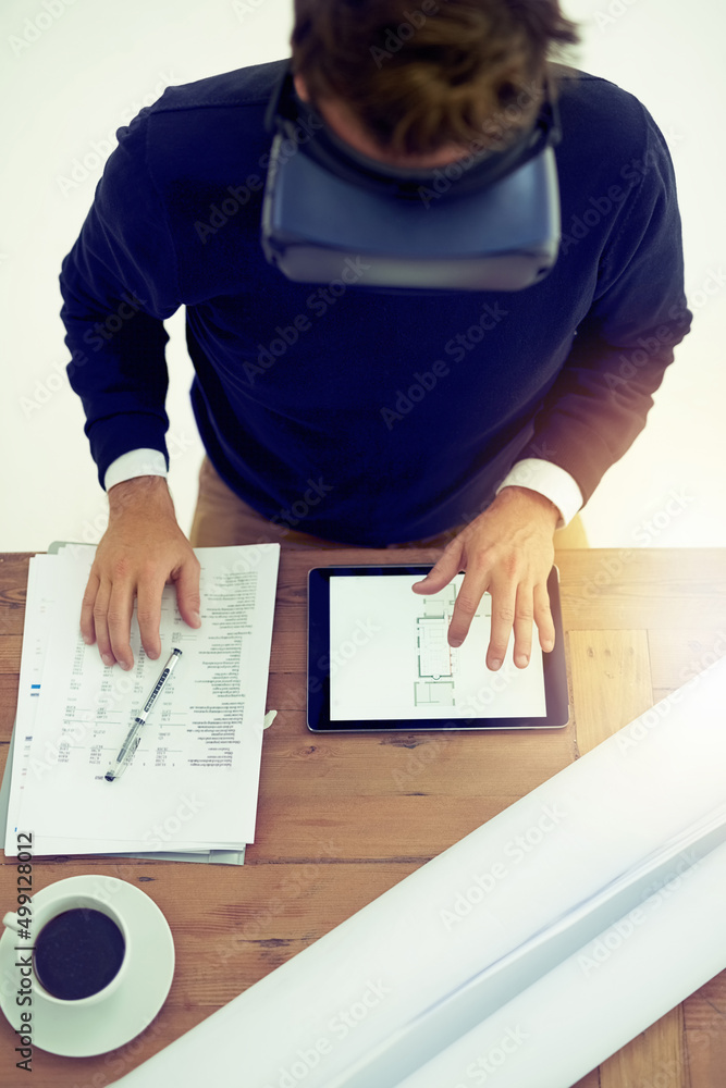 Poster Getting work done more efficiently through the virtual world. High angle shot of a businessman wearing a VR headset while working in an office.